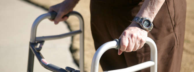 Idoso utilizando andador adulto para apoio e mobilidade ao ar livre.