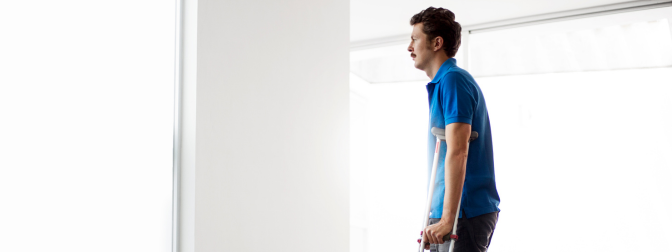 Homem utilizando muletas em ambiente iluminado, representando o tema onde comprar muletas com segurança e conforto.