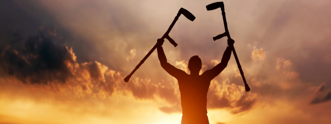 Pessoa erguendo muletas ao pôr do sol, simbolizando superação e o impacto social do empréstimo de muletas